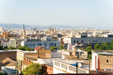 Aerial view of the Barcelona skyline with many buildings on a sunny summer day