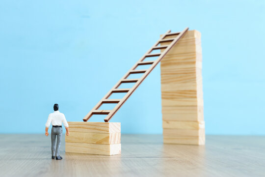 business concept picture of challenge. A man stands on the edge of a high wall and passes the gap by placing a ladder. Problem solving and decision making.