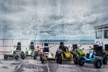 Go carts on the Belgian coast, observed through the rainy window of a cafe.