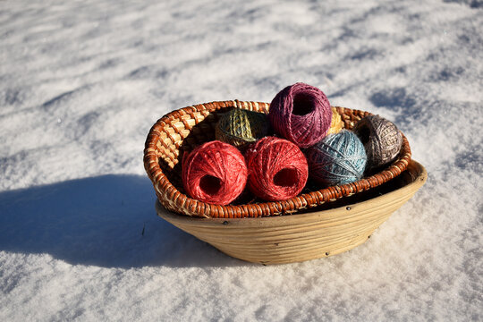 basket with colorful silk balls for easter in the snow with sun