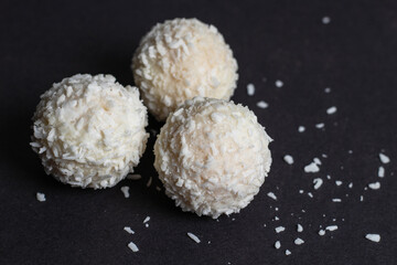 White sweet, covered the coconut shaving on a dark background