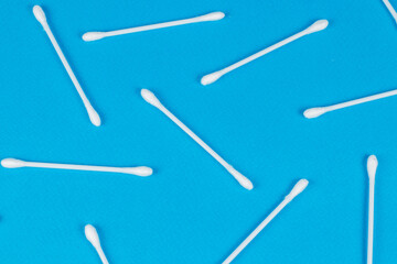 Cotton swabs on blue background. Top view ear sticks.