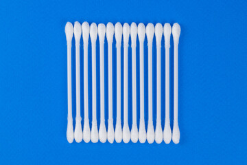 White cotton swabs on blue background.