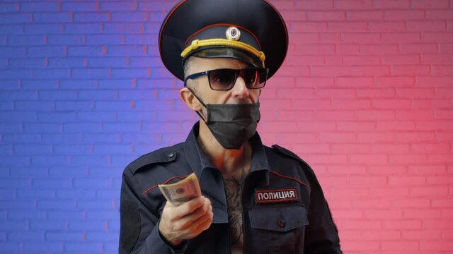 a man in a military uniform of the Russian police with a coronavirus mask counts the money. English translation police, Russia