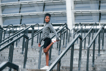 On the stairs. Young african american woman in sportive clothes have workout outdoors at daytime