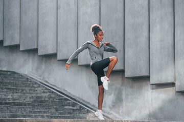 Conception of sport. Young african american woman in sportive clothes have workout outdoors at daytime