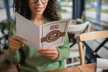 cropped view of african american woman holding menu in cafe