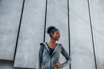 Young african american woman in sportive clothes have workout outdoors at daytime