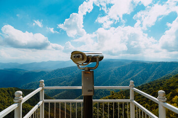 Fototapeta na wymiar Coin Operator Binocular viewer Landscape with a beautiful cloudy sky and mountains ..