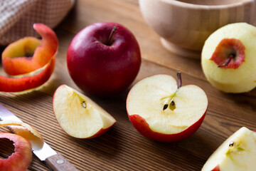 Red apples slices on wooden rustic table.