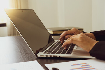 ..The hand of an Asian female finance worker is typing on a laptop keyboard to check e-mail, to collect information. To be presented at tomorrow's meeting