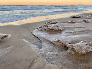 Winter sunset at Gillson Beach along Lake Michigan's Illinois shore. Waves left carvings on the beach which iced over from the frigid air.