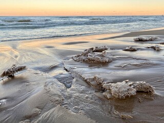 Winter sunset at Gillson Beach along Lake Michigan's Illinois shore. Waves left carvings on the beach which iced over from the frigid air.