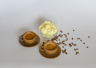 A cup of coffee, a delicate meringue dessert and coffee beans on a light background