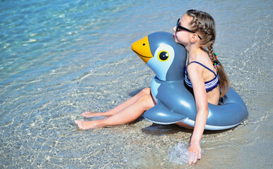  Summertime. Little girl swims in clear sea. Summer concept.