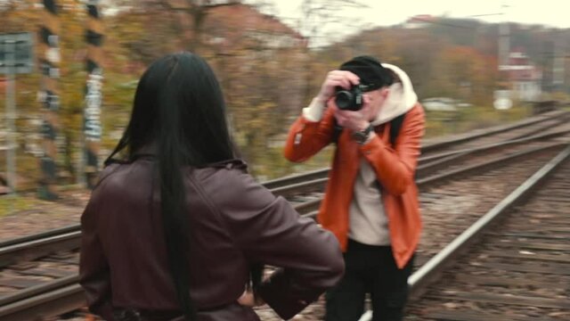 The photographer makes a photo session on the railway. The model is posing. Take photos for your portfolio. Living the image in the community of the casting agency.