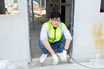 Asian man construction worker looking stressed on construction site.