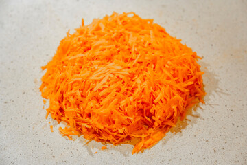 Orange textured surface of freshly grated carrots for a variety of healthy dishes