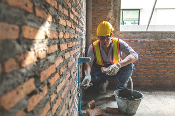 Man bricklayer installing bricks on construction site