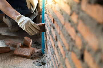 Man bricklayer installing bricks on construction site