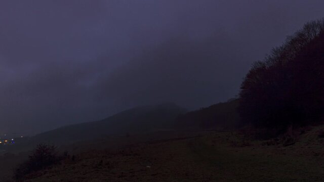Small town against misty montain at sunset. Timelapse
