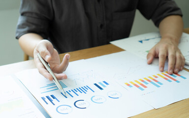 Asian male finance staff Is explaining the performance from the company's rapidly growing bar graph this year. To his boss On the desk at the office, Finance concept