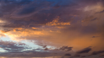 Crépuscule serein, sous un ciel parsemé de quelques passages nuageux, aux reflets dorés