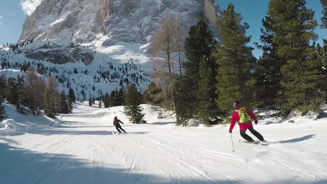 Recreational skier ski carving downhill, camera follows in Alps in Val Gardena Italy
