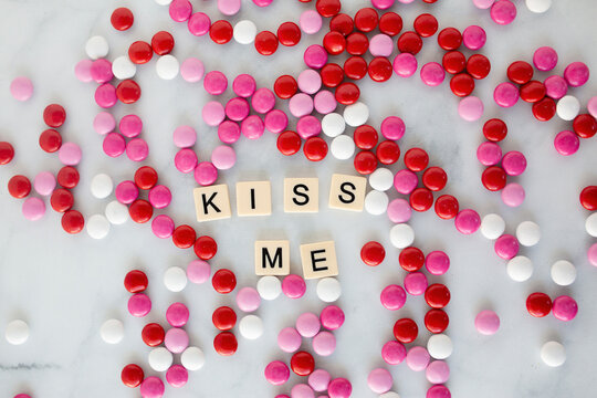 The Words Kiss Me Written In Scrabble Tiles On A Marble Kitchen Counter Top Surrounded By Valentines Candy