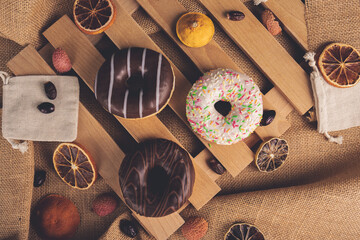 Donuts on wooden and linen background
 - obrazy, fototapety, plakaty
