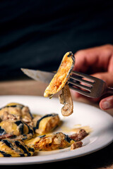 Chef hands showing slice of dumplings on the black background..