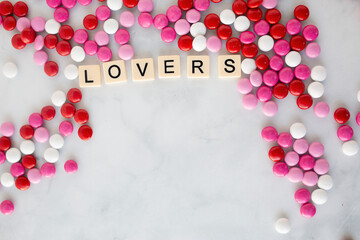 the words lover written in scrabble tiles on a marble kitchen counter top surrounded by valentines candy