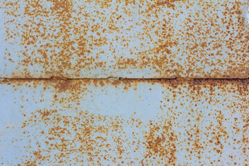 Light blue corroded metal background. Rusty and scratched painted metal wall. Rusty metal background with streaks of rust .