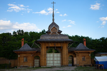 Fototapeta premium large horizontal photo. summer time. Russia. Belgorod. Christian temple against the background of a clear blue sky with white clouds. Orthodox cross. sunset light. Orthodox Church.