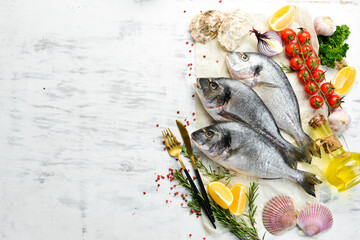 Raw dorado fish with spices. On a white wooden background. Top view.