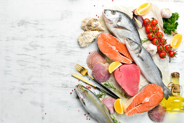 Seafood background: salmon, tuna, caviar, oysters, dorado fish and shellfish on a blue wooden...