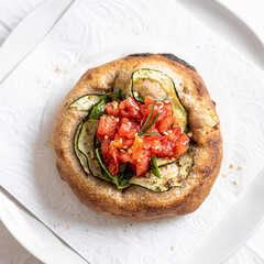 Focaccia with tomato and zucchini on white background