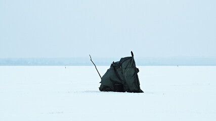 Tent of the fisherman on the ice of a winter lake