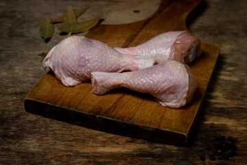 Raw chicken legs on a wooden board. Chicken legs on an old wooden surface. Chicken meat.