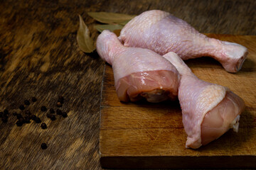 Raw chicken legs on a wooden board. Chicken legs on an old wooden surface. Chicken meat.