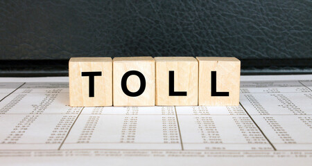 Word Toll made with wood toy blocks on financial tables