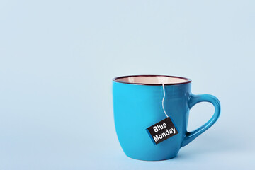 Tea bag with Blue Monday text in blue mug on blue background. Most depressed day of the year concept