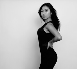 Naklejka premium Beautiful asian woman with long black hair posing in dress on grey background