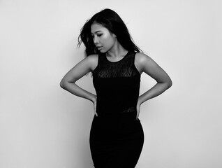 Fototapeta premium Beautiful asian woman with long black hair posing in dress on grey background