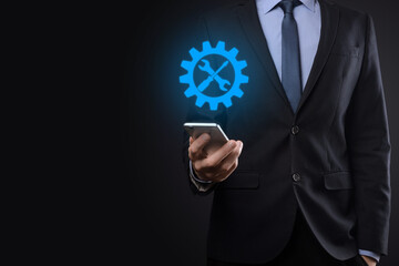 Businessman holding gear icon with tools.Gearing.Concept of target focus digital diagram,graph interfaces,virtual UI screen,connections netwoork.