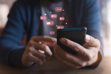 Man hand using a social media marketing concept on mobile phone with notification icons of like,...