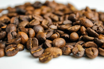 Roasted coffee beans on a white background.