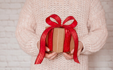 Girl holding a gift box with big red ribbon bow