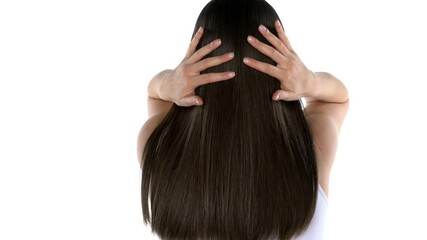 young brunette tossing her hair and turn with a smile to the camera on a white background - Powered by Adobe