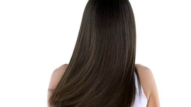 slow motion of a young brunette shaking her hair and turning smiling to the camera on a white background